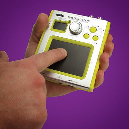 A small handheld musical instrument about the size of a poptart, with a touchpad occupying most of the front along with a few smaller buttons and widgets.